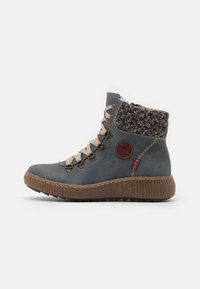 Botín de cuero gris con puño de punto, cordones beige y suela de goma texturizada. Presenta costuras decorativas y un acento de logo.