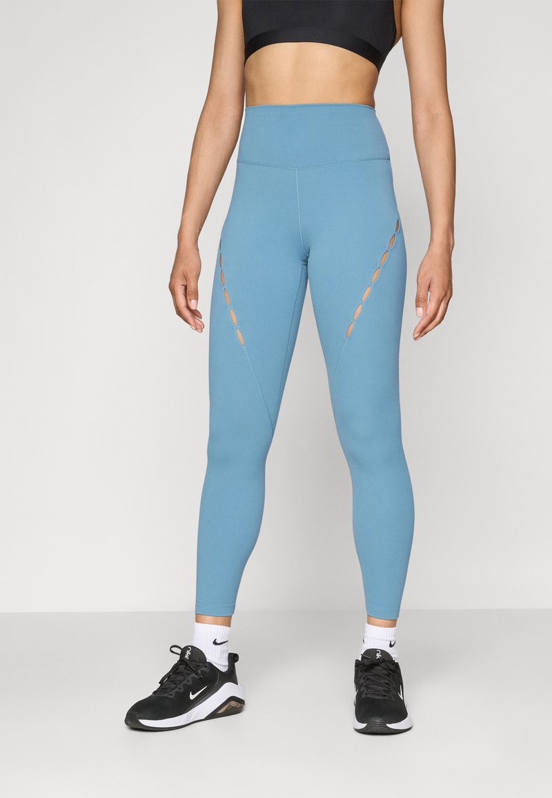 Világoskék, magas derekú sportleggings, vágott részletekkel az oldalain. Nyújtható, nedvességelvezető anyagból készült.