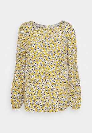 Blouse jaune à manches longues avec un col froncé et des poignets élastiques, présentant un motif floral dense blanc et bleu.