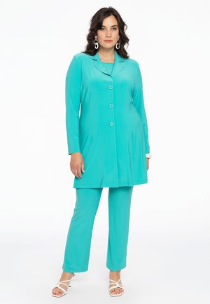 Turkis outfit i to dele bestående af en langærmet skjorte med knapper og matchende slanke bukser, lavet af glat stof med en blød tekstur.