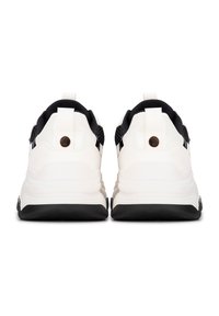 Zapatillas blancas y negras con parte superior de tejido texturizado, cuello acolchado y una gruesa suela negra con ranuras horizontales.