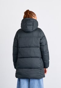 Svart boblejakke med hette, med quiltede paneler og glatt tekstur. Jakken rekker til midt på låret, egnet for kaldt vær.