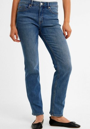 Siniset denim-farkut suoran lahkeen mallilla, viisi-taskista tyyliä, kontrastia ompeleet ja kevyt haalistuminen, yhdistettynä mustiin ballerinoihin.