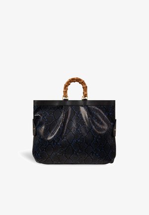 Sac à main noir et bleu à motif serpent, avec de courtes poignées en bambou et des finitions en cuir noir, présenté sur un fond blanc.