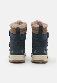 Blauwe en bruine laarzen met een zachte, donzige tan voering, een gestructureerde suede en mesh buitenkant, en een robuuste zool, met trektabs aan de achterkant.