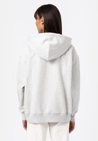 Gray cotton hooded sweatshirt with a relaxed fit, kangaroo pocket, and ribbed cuffs. Features a large hood and soft texture.