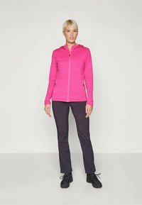 Fuchsiová mikina na zips s dlhými rukávmi, textúrovaná tkanina, skombinovaná s tmavými nohavicami a čiernou obuvou. Jednoduchý dizajn, funkčná pre aktívne nosenie.