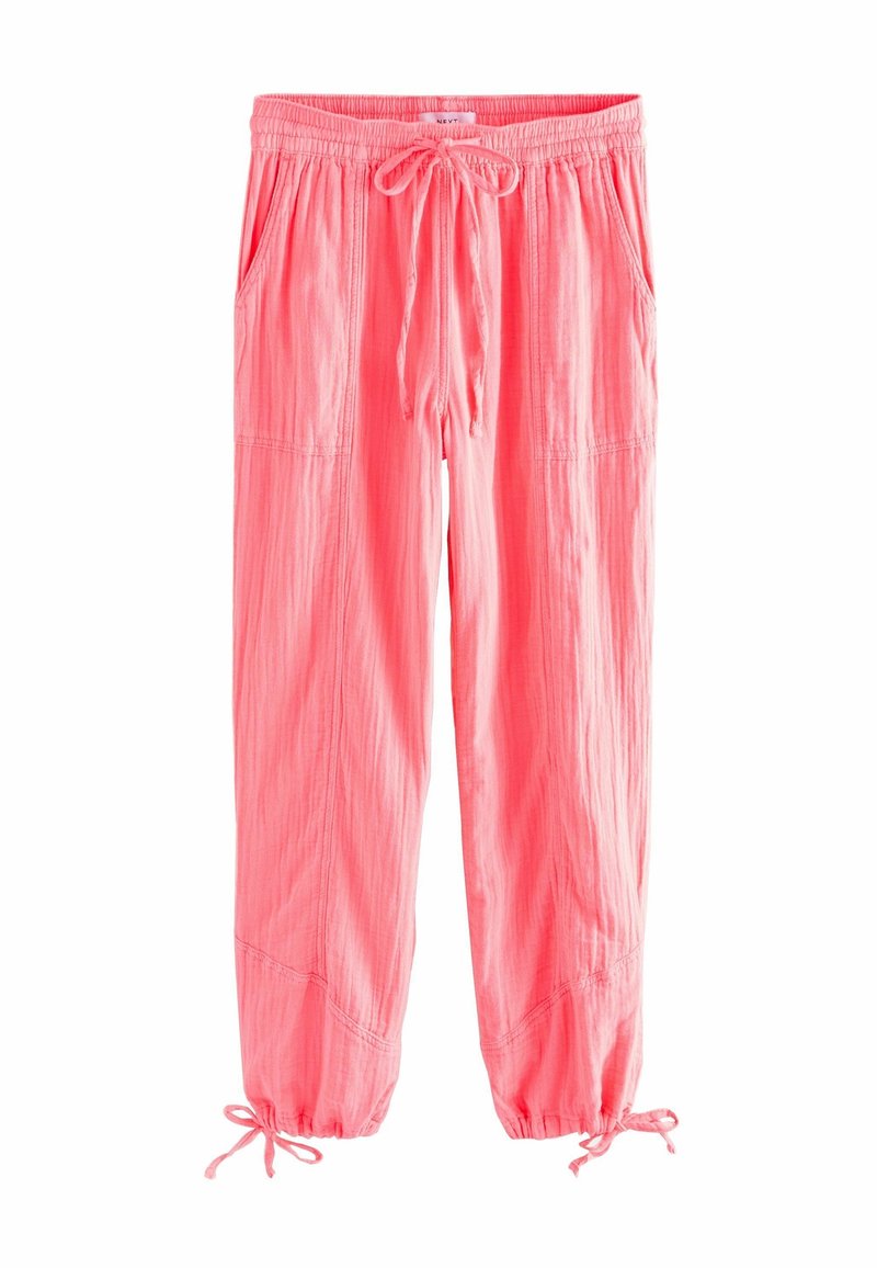 Pantalon léger rose avec taille élastique et cordon, poches latérales et liens aux poignets élastiqués.