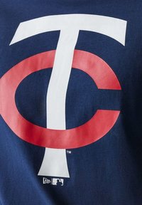 Verschränktes weißes "T" und rotes "C" Logo auf marineblauem Stoff, mit kleinen MLB- und New Era-Logos darunter.