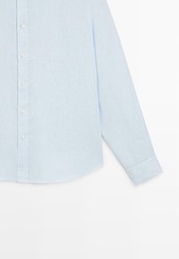 Light blue long-sleeve button-up shirt with white buttons and a single cuff on the right sleeve, displayed on a white background.