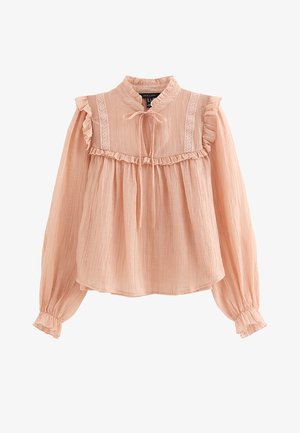 Blouse rose clair à manches longues avec volants sur les épaules et les poignets, bordure en dentelle, col montant et détail de nœud à l'avant.