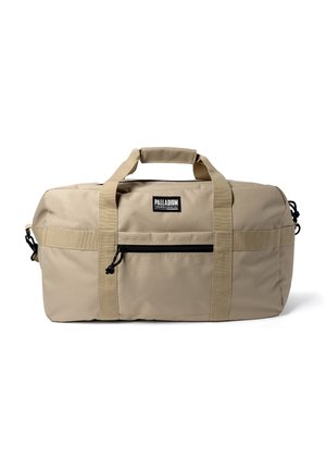Sac de sport rectangulaire beige avec poche zippée à l'avant, double poignées solides avec prise rembourrée, et étiquette de la marque Palladium centrée au-dessus de la poche.