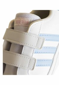 Sneaker bianca in pelle con strisce azzurro chiaro, colletto in rete testurizzata e fasce in velcro regolabili. Presenta cuciture visibili e un'etichetta con il logo.