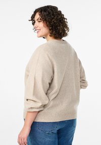 Beidzot dzija džemis ar apaļu kakla izgriezumu un apjomīgām piedurknēm, apvienots ar ziliem džinsiem. Mīksta tekstūra ar ribotām aprocēm un apakšmalu.