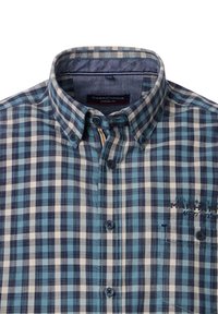 Button-up shirt with a blue, navy, and cream checked pattern. Features a collar, front buttons, and stitched detailing on the left chest.