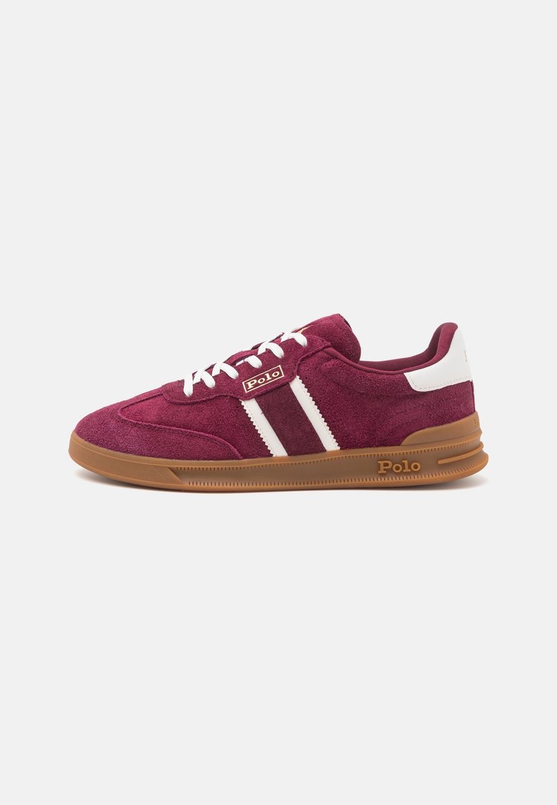 Baskets en daim bordeaux avec lacets blancs, bandes blanches et semelle en caoutchouc marron, siglées "Polo" sur le côté et au talon.