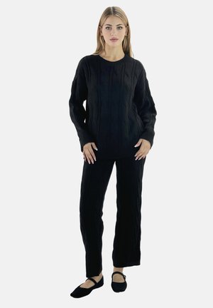 Maglione lavorato a maglia nera con pantaloni abbinati. Il maglione presenta polsini a costine e un colletto rotondo; i pantaloni hanno una linea dritta. Consistenza morbida.
