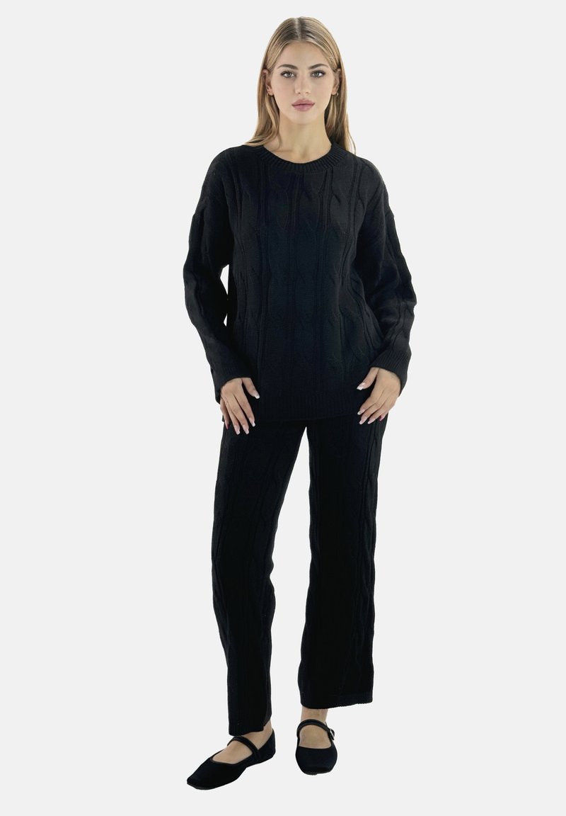 Maglione lavorato a maglia nera con pantaloni abbinati. Il maglione presenta polsini a costine e un colletto rotondo; i pantaloni hanno una linea dritta. Consistenza morbida.