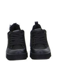 Zapatillas negras que combinan tejido texturizado y material sintético liso. Punta redondeada, suela de contraste y diseño con cordones.