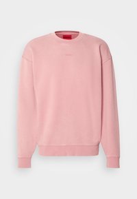 Sweat-shirt rose à col rond avec manches longues et broderie discrète du logo "HUGO" sur la poitrine, présenté sur un fond uni.