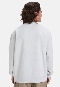 Grå sweatshirt med en afslappet pasform, rund halsudskæring, raglanærmer og ribbede manchetter. Blød tekstur med et minimalistisk design.