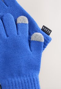 Kék kötött kesztyű szürke ujjvégekkel és bordázott mandzsettákkal. A fekete címkén "BAKER by TED BAKER" felirat látható, amely a mandzsettához van csatolva.