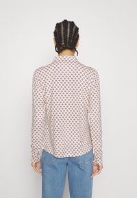 Langsleeve shirt in lichtcrème met maroon geometrisch patroon, met een kraag en een licht gebogen zoom, gemaakt van gladde stof.