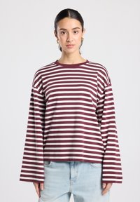 Langärmliges gestreiftes Hemd in Burgunderrot und Creme, mit lockerem Schnitt und weiten Ärmeln. Hergestellt aus weichem Baumwollmischgewebe.