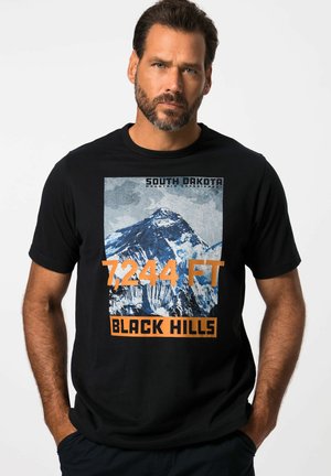 Černé bavlněné tričko s grafikou hory a nápisy "SOUTH DAKOTA," "7,244 FT," a "BLACK HILLS" v oranžovém písmu. Krátké rukávy.
