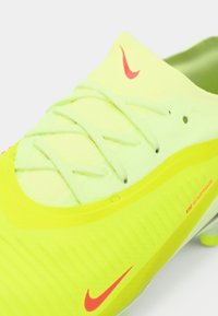 Coadă de fotbal galben strălucitor cu suprafață texturată, accente verzi, logo roșu Nike și șireturi verde-Deschis. Proiectată pentru performanță și aderență.