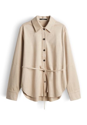 Camicia beige a maniche lunghe con bottoni, collo appuntito e sottile cintura in vita, realizzata in tessuto liscio, mostrata distesa su sfondo bianco.