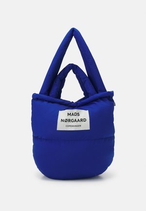 Sac tote bleu matelassé avec deux poignées matelassées et une étiquette blanche indiquant "Mads Nørgaard Copenhagen" sur le devant.