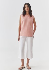 Heledad roosa linane sleeveless top ümarate kaelus, koos valgete pahklaiuste laia säärega pükstega ja rihmadega sandaalidega.
