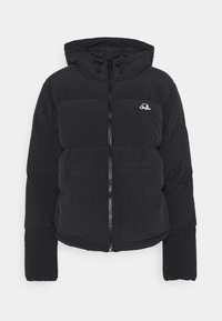 Svart puffjacka med dragkedja fram, huva och elastiska muddare. Har en liten logotyp på bröstet och ett quiltat mönster för isolering.