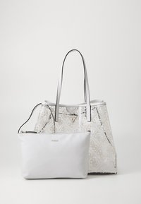 Sac fourre-tout en matériau blanc à motifs avec des accents argentés. Il dispose de deux poignées solides et d'une pochette assortie amovible.