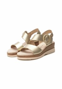Sandalias de cuña de cuero dorado con dos correas anchas, un hebilla decorativa redonda y una suela de madera clara texturizada.