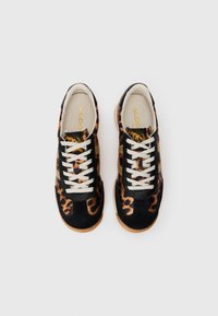 Et par leopardmønstrede sneakers med sorte ruskindsdetaljer, hvide snørebånd og beige såler, set ovenfra på en hvid baggrund.