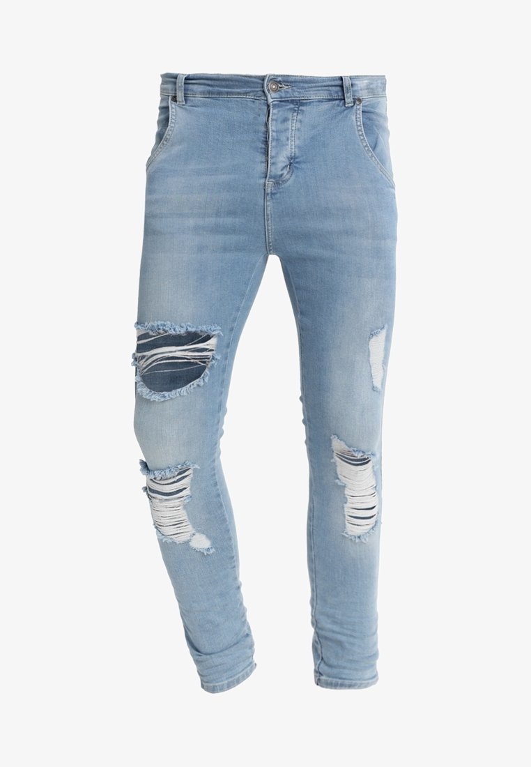 Vaqueros de mezclilla azul claro con un ajuste slim, áreas desgastadas en las rodillas y bordes deshilachados. Diseño clásico de cinco bolsillos con cierre de botón.