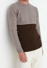 Maglione da uomo lavorato a maglia con una sezione superiore grigio chiaro e una sezione inferiore marrone scuro. Il materiale sembra morbido, con polsini e orlo a coste.