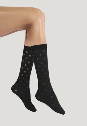 Calze nere al ginocchio in materiale liscio, caratterizzate da un motivo di piccoli disegni floreali in una tonalità metallica a contrasto.