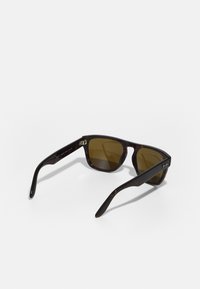 Ochelari de soare tortoise brown cu lentile rectangulare. Lentilele au o nuanță de marron, iar brațele au un finisaj neted cu accente din metal.