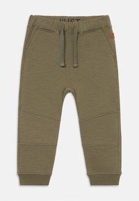 Pantalons de survêtement vert olive avec une taille élastique à cordon, poches latérales et surpiqures sur les jambes, présentés sur un fond blanc.