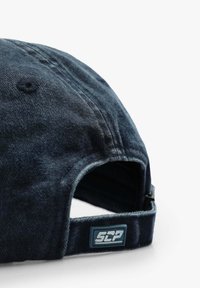 Dunkelblaues Cap aus strukturiertem Stoff, mit gebogenem Schirm und verstellbarem Riemen. Besitzt ein hellblaues rechteckiges Logopatch auf der Rückseite.