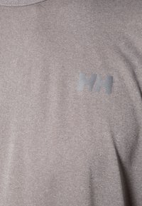 Ljusgrå t-shirt med kort ärm och slät textur, med en silvrig "HH"-logotyp på framsidan. Enkelt design utan ytterligare mönster.