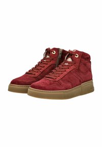 Baskets montantes en suède rouge avec semelles en caoutchouc marron, à lacets à l'avant, zips sur les côtés et œillets dorés, vue latérale en angle.