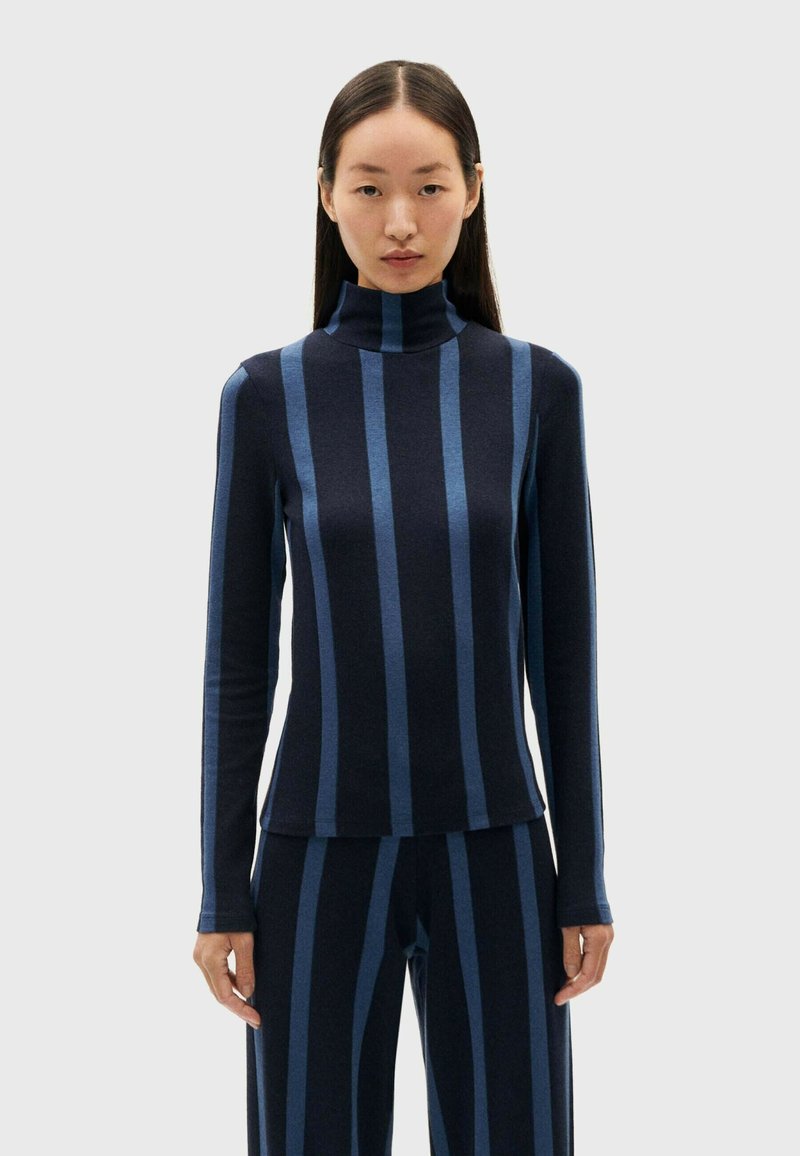 Navy turtleneck top met donkerblauwe verticale strepen, lange mouwen, aansluitend ontwerp en zachte textuur, gecombineerd met bijpassende gestreepte broek.