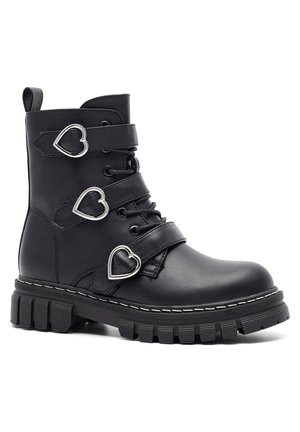 Czarny skórzany but bojowy z masywną podeszwą, trzema srebrnymi klamrami w kształcie serca na paskach oraz sznurowaniem z przodu.