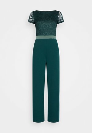 Dunkelgrüner Overall mit Spitzen-Details an den kurzen Ärmeln und am oberen Oberteil, durchgehende weite Beine und einem passenden Taillengürtel.