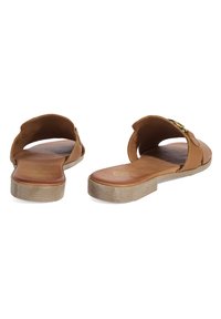 Braune flache Sandalen mit offenem Rücken, strukturiertem Lederobermaterial und einer hellen, geriffelten Sohle. Mit einem dekorativen goldenen Schnallenakzent.