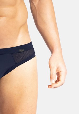 Maillots de bain en bleu marine avec panneaux en mesh, taille élastique et design ajusté. Vue rapprochée du côté et de la partie supérieure de la cuisse, mettant en valeur la texture.
